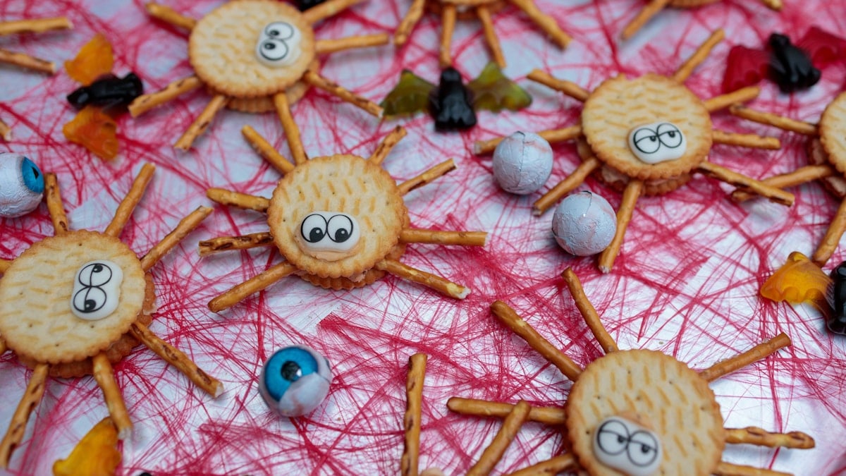 A close up of a plate of cookies with spider decorations
